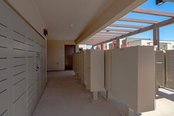 A long hallway with white lockers on the left and a row of white booths on the right.